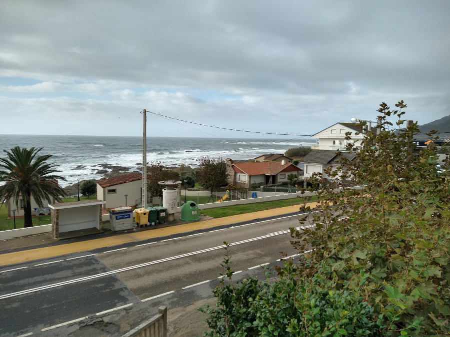 View of road and crashing ocean waves.