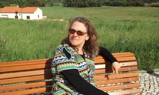Aothor Rosemary Mann sitting on a bench.