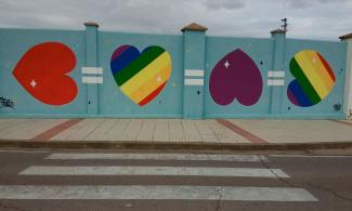 Rainbow striped LGBTQ+ mural.