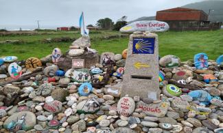 A camino waymarker with painted stones.